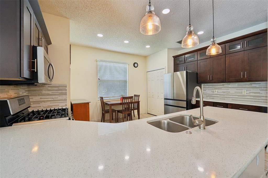 OVERSIZED KITCHEN Renovated in 2020 with UPGRADED QUARTZ COUNTERTOPS, NEWER STAINLESS-STEEL APPLIANCES, GAS RANGE, NEW CABINETS & PLENTY OF ROOM for an EAT-IN KITCHEN SPACE.