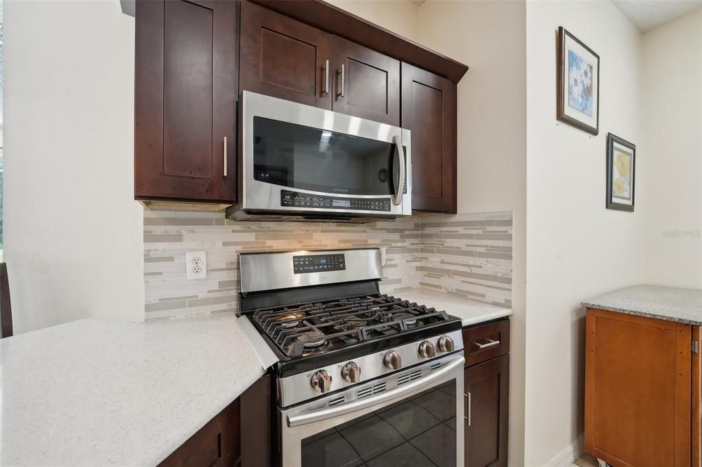 OVERSIZED KITCHEN Renovated in 2020 with UPGRADED QUARTZ COUNTERTOPS, NEWER STAINLESS-STEEL APPLIANCES, GAS RANGE, NEW CABINETS & PLENTY OF ROOM for an EAT-IN KITCHEN SPACE.