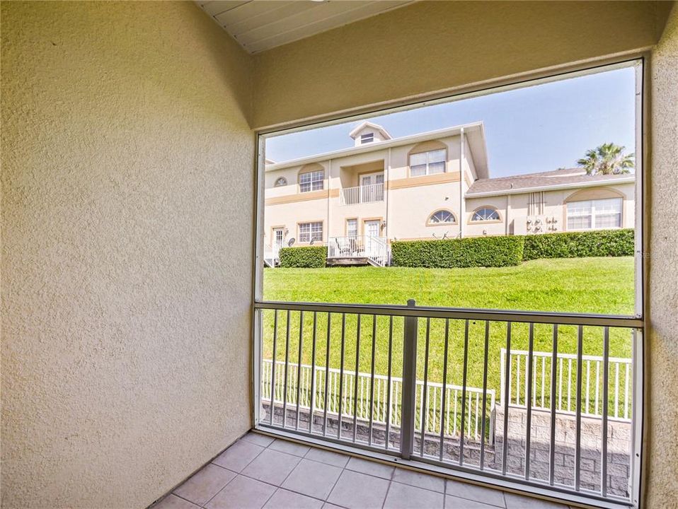 Screened balcony with green area view.