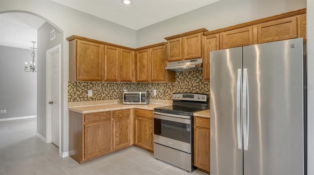 Spacious kitchen featuring ample cabinetry, solid surface countertops, stainless steel appliances, and more!