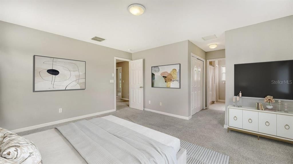 Owners suite featuring large windows, walk-in closets, and an ensuite bathroom.