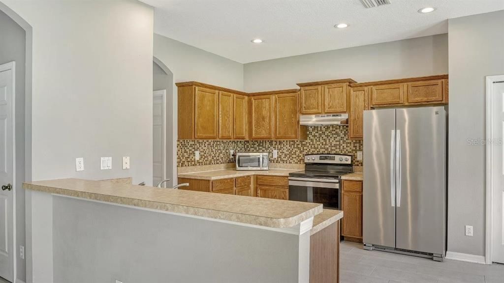 Spacious kitchen featuring ample cabinetry, solid surface countertops, stainless steel appliances, and more!