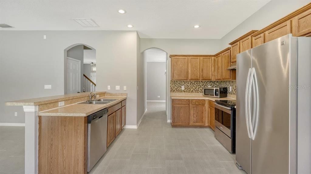 Spacious kitchen featuring ample cabinetry, solid surface countertops, stainless steel appliances, and more!