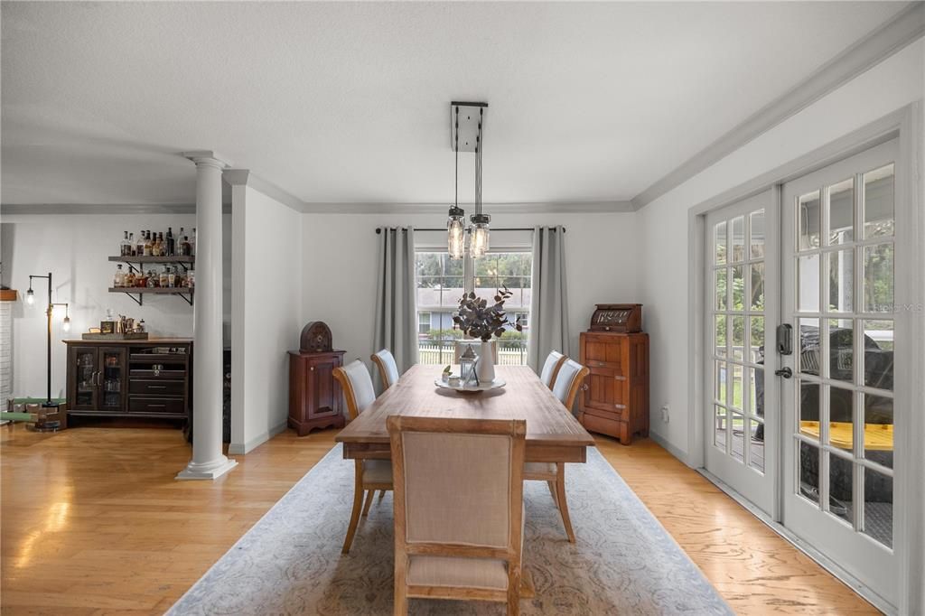 Open dining from kitchen to living room with a view of the pool