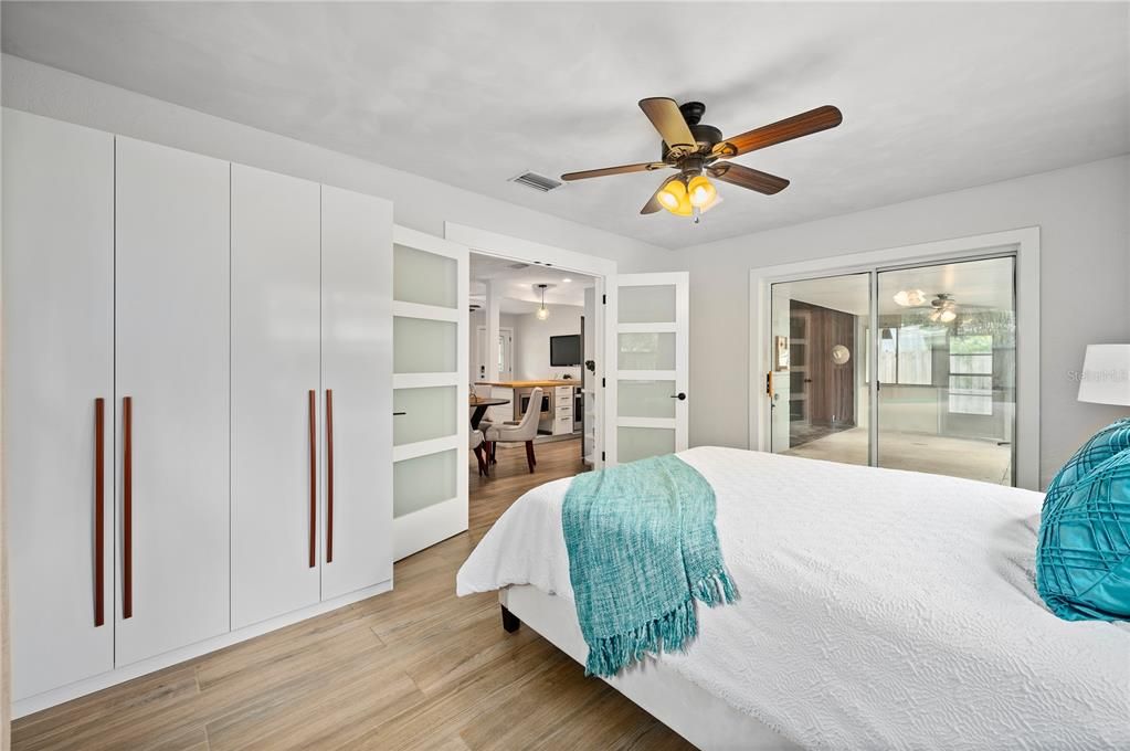 Master bedroom with frosted glass pane door. Notice the sliding glass door to the patio and the brand new storage closet