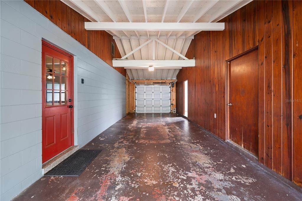 Tandem Garage. a thought here if the garage was not a priority is that with the exposed trusses, was that this could be converted to a living space or bedroom as there is a bathroom in place to the back right of this photo.