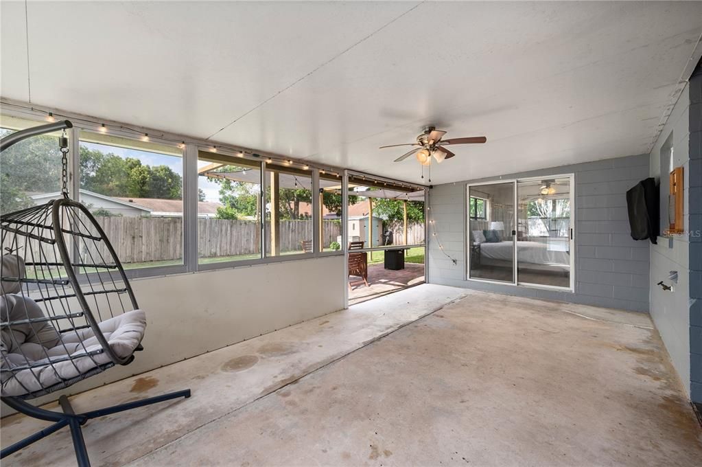 Covered and enclosed rear patio with a retracting screen to open the space up.