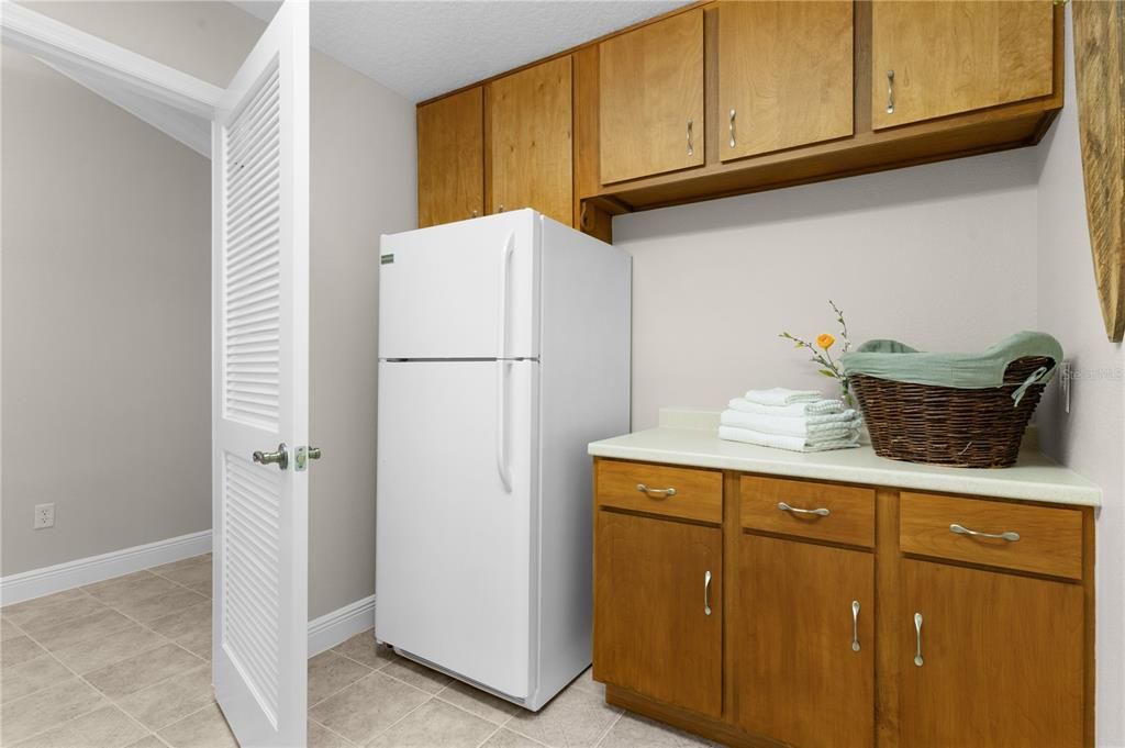 Laundry room with folding counter & cabinets & extra frig