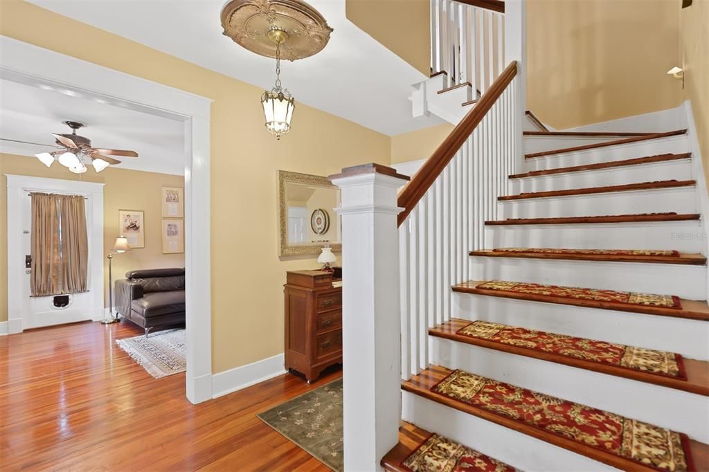 Inside front door, welcoming staircase and entrance into living room