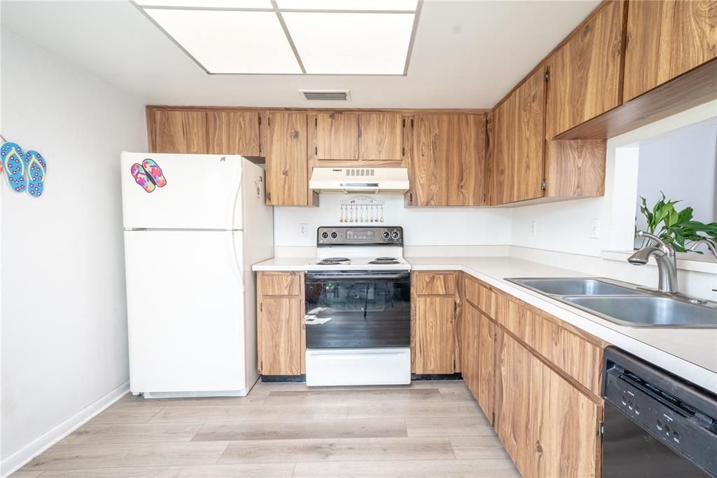 The kitchen features a suite of appliances including a refrigerator, range and hood and dishwasher.