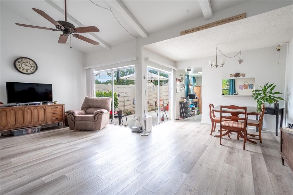The open floor-plan features vinyl plank flooring in the living and dining areas, with sliding glass doors that lead to a private fenced in patio.