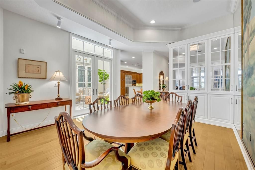 Custom built-in glass cabinets with lighting on either side of the dining room