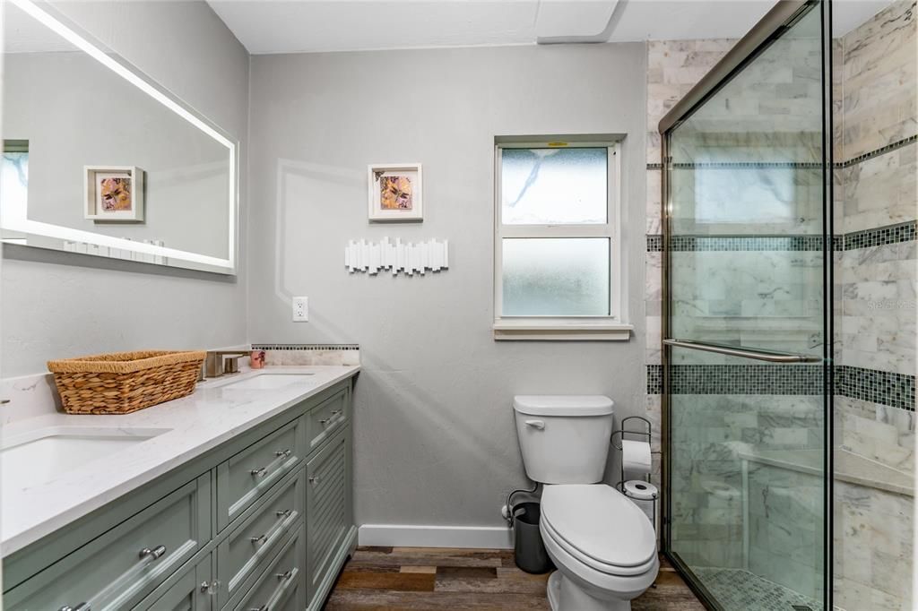 Lovely and unique seafoam green wood cabinetry with marble counter