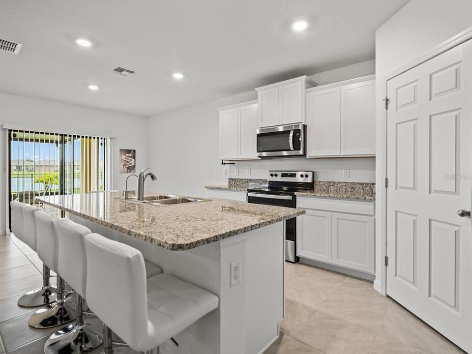 View of the kitchen after passing the flex room, facing the covered back patio in the back