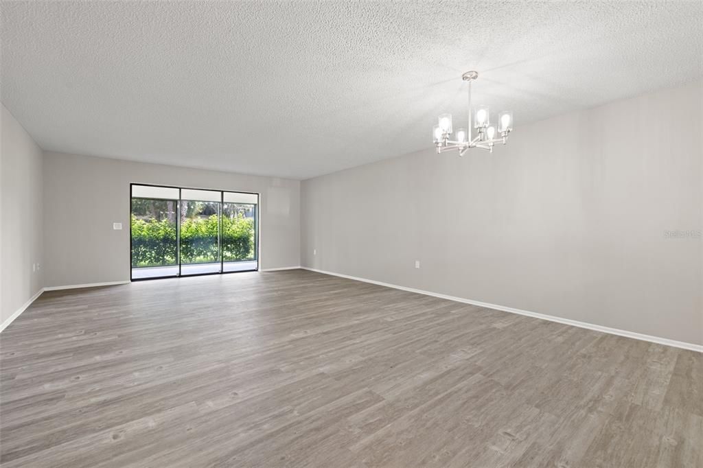 Living room and dining room combo with new light fixture and new luxury vinyl flooring