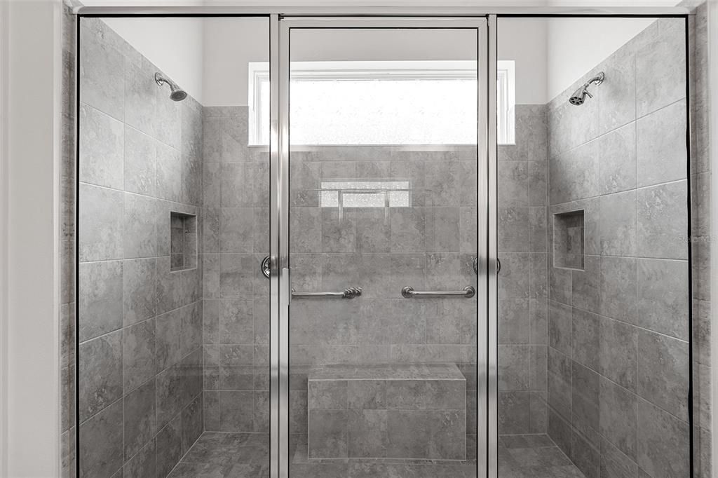 Luxurious shower with multiple shower heads and bench