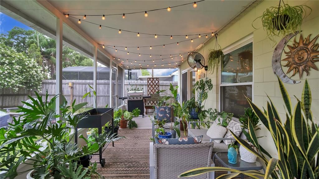 Screened Back Porch with Market Lighting overlooking the fully fenced, lush yard.