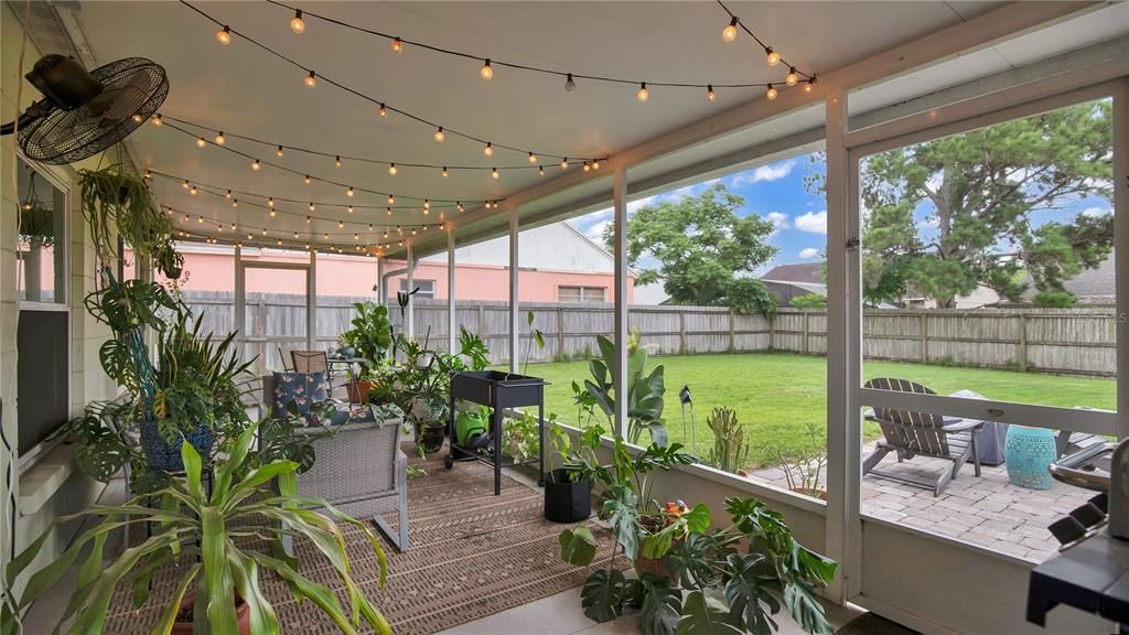 Screened Back Porch with Market Lighting overlooking the fully fenced, lush yard.