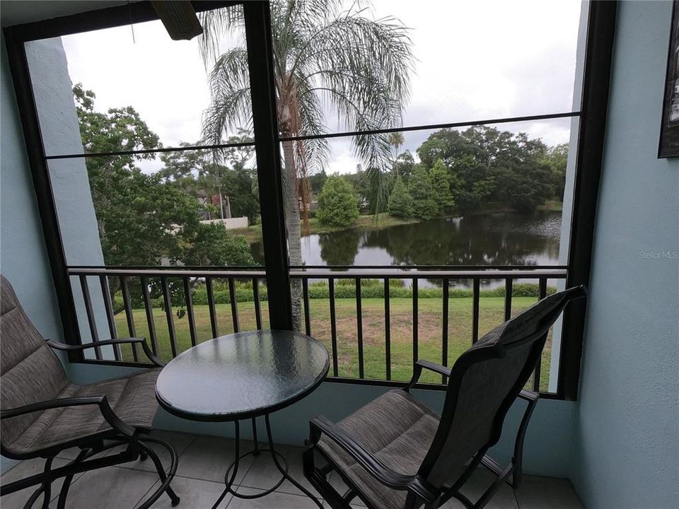 Living room with balcony and view of pond