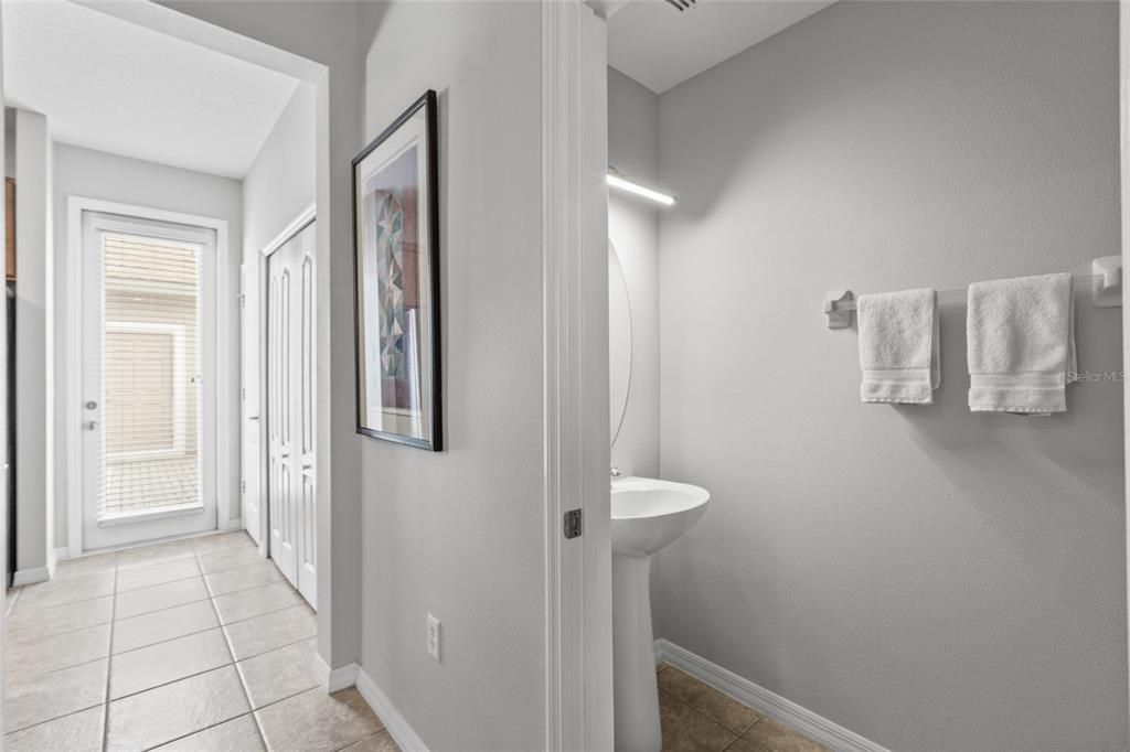 View of the back door leading to the patio and the half bath.