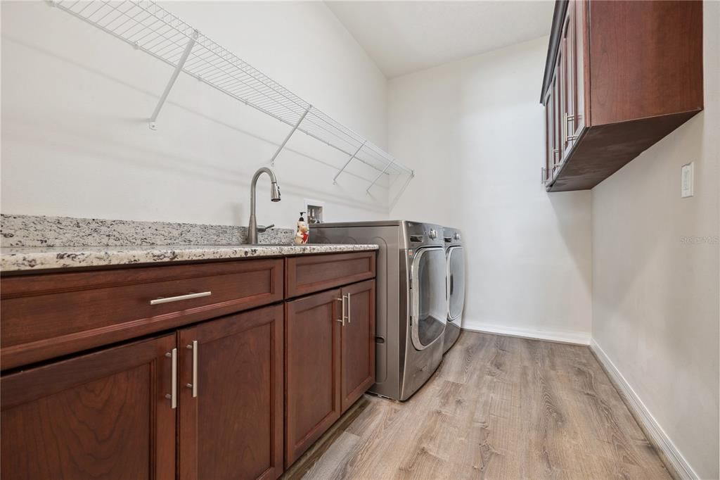 Ample space in laundry room with cabinetry and granite countertops