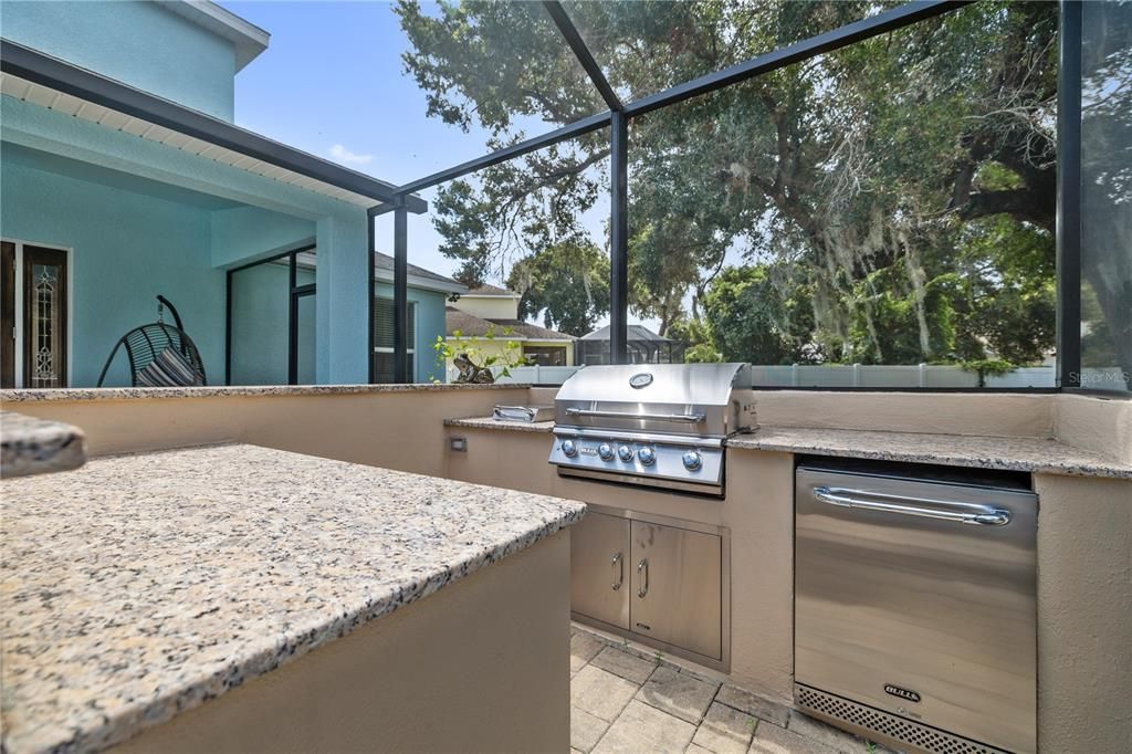 Host wonderful BBQs with your outdoor kitchen (BULL grill, rotisserie, burner and refrigerator, set in granite countertops)