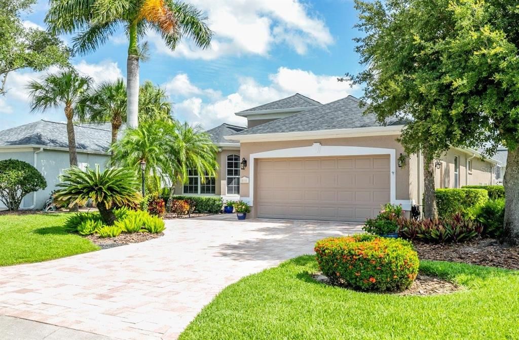 Front elevation Showing the beautiful landscaping, front entryway, and paver driveway.