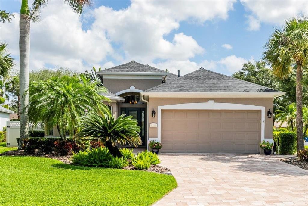 Front elevation Showing the beautiful landscaping, front entryway, and paver driveway.