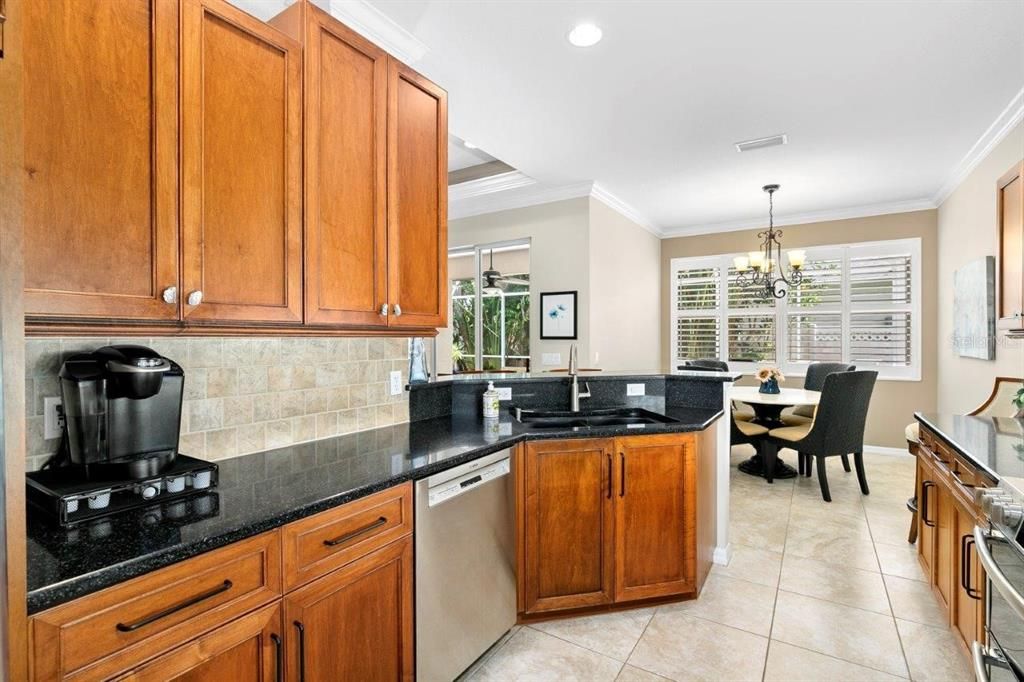 Large galley kitchen with solid wood cabinets, stainless steel appliances, a breakfast bar, dinette, and large pantry.