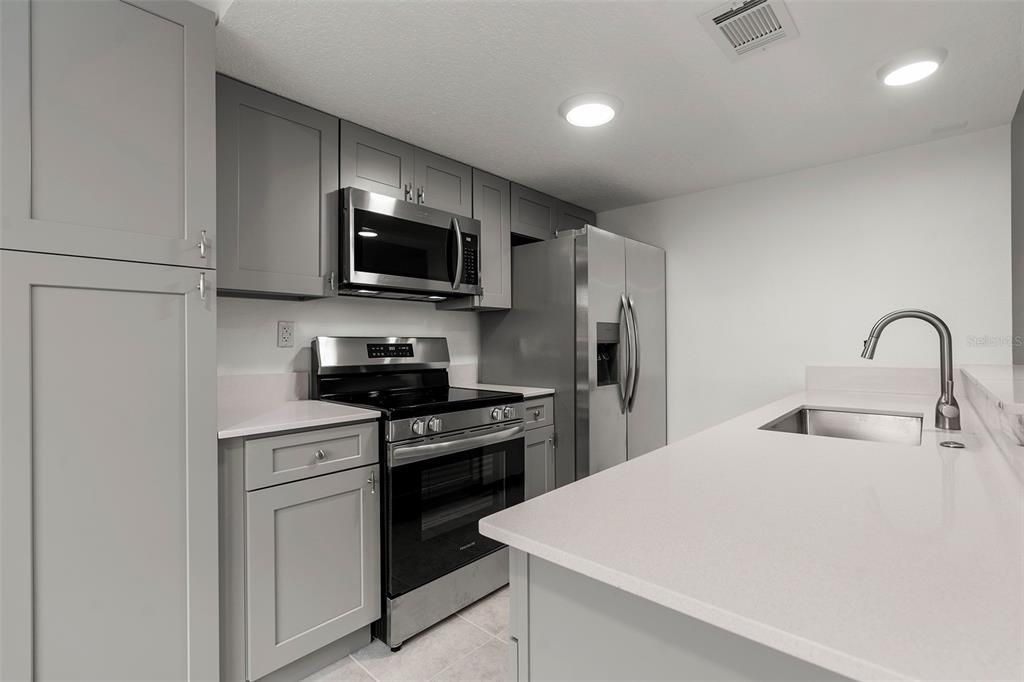 Kitchen with stainless steel appliances and quartz countertops