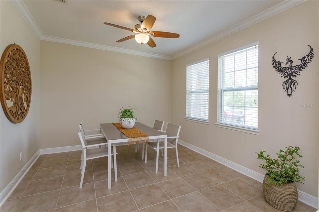 Dining room with tile floors and crown molding
