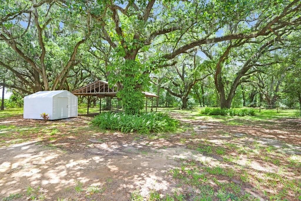 Expansive property with storage shed & pole barn in the background