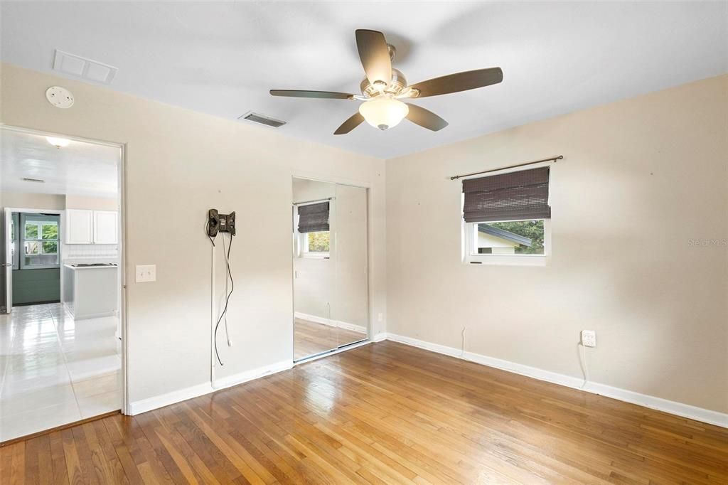 Bedroom two with mirrored closet doors and ceiling fan.