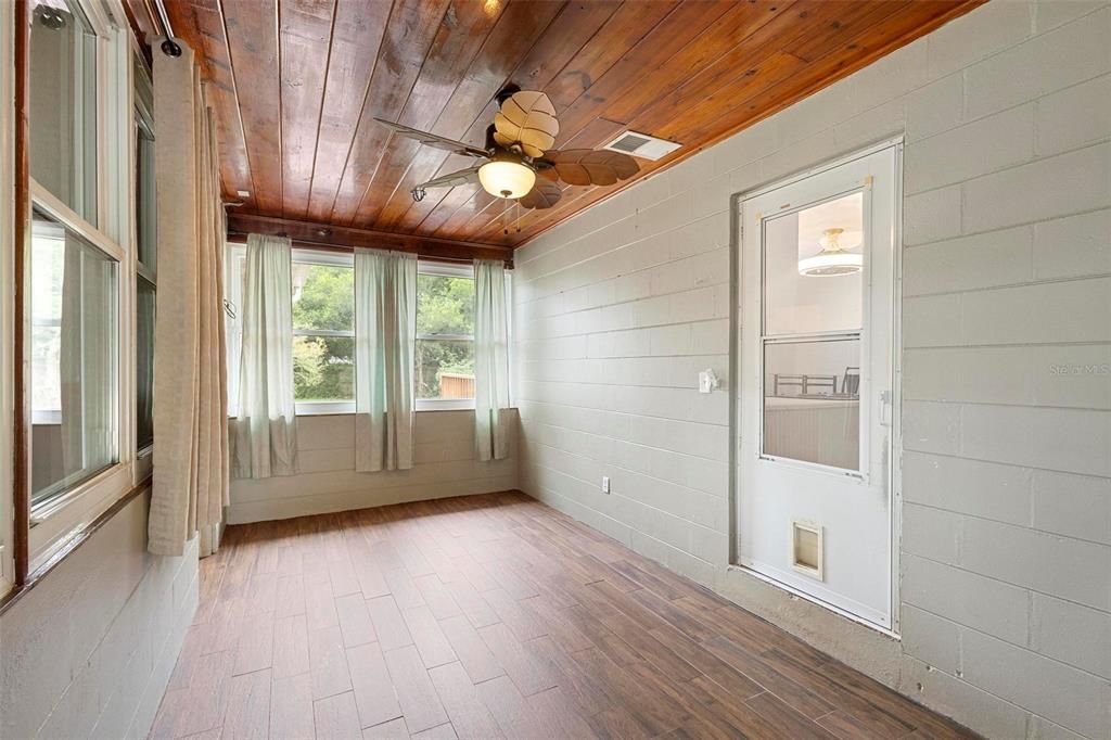 Den looking at the door that leads to the main part of the home. Updated windows provide great natural light.