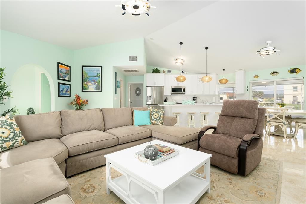 Living room featuring high vaulted ceiling and light tile floors