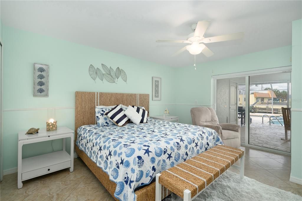 Bedroom featuring tile flooring, ceiling fan, and access to exterior