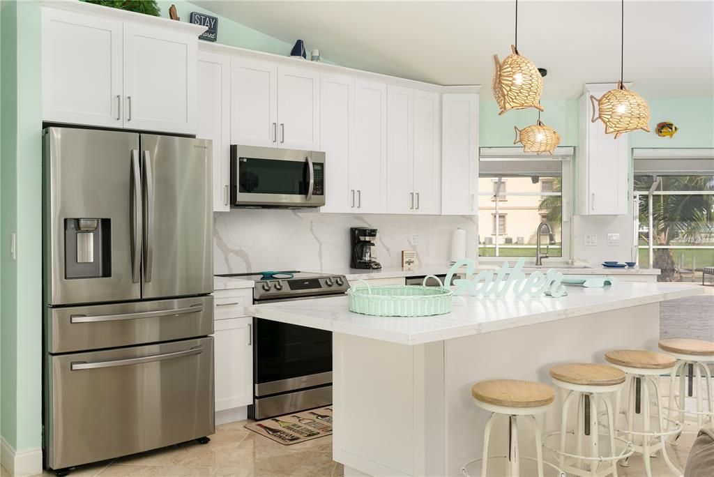 Kitchen with tasteful backsplash, white cabinetry, an island with
