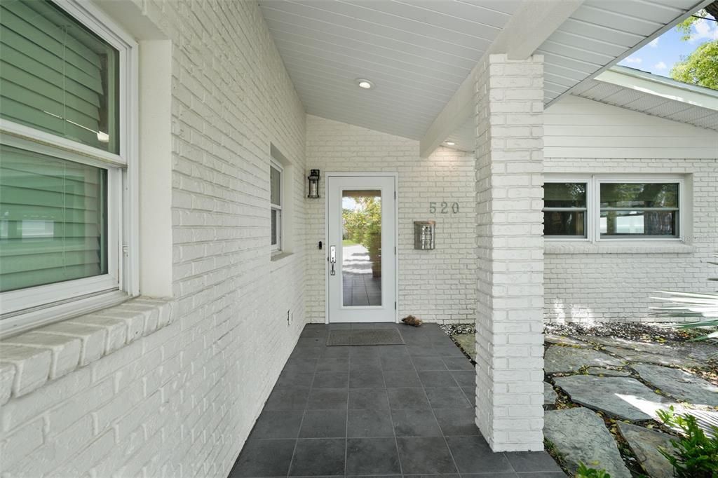 Pavered entry leads to front door and outdoor living in front yard