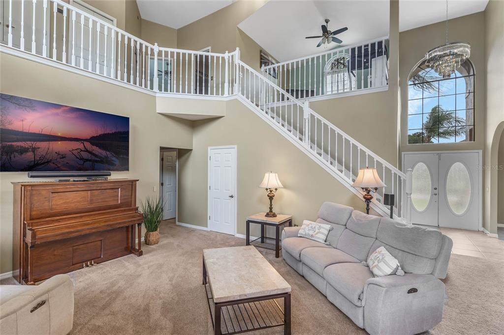 View of the Foyer with lovely Glass Front Doors and large natural light windows. Open Staircase and loft.