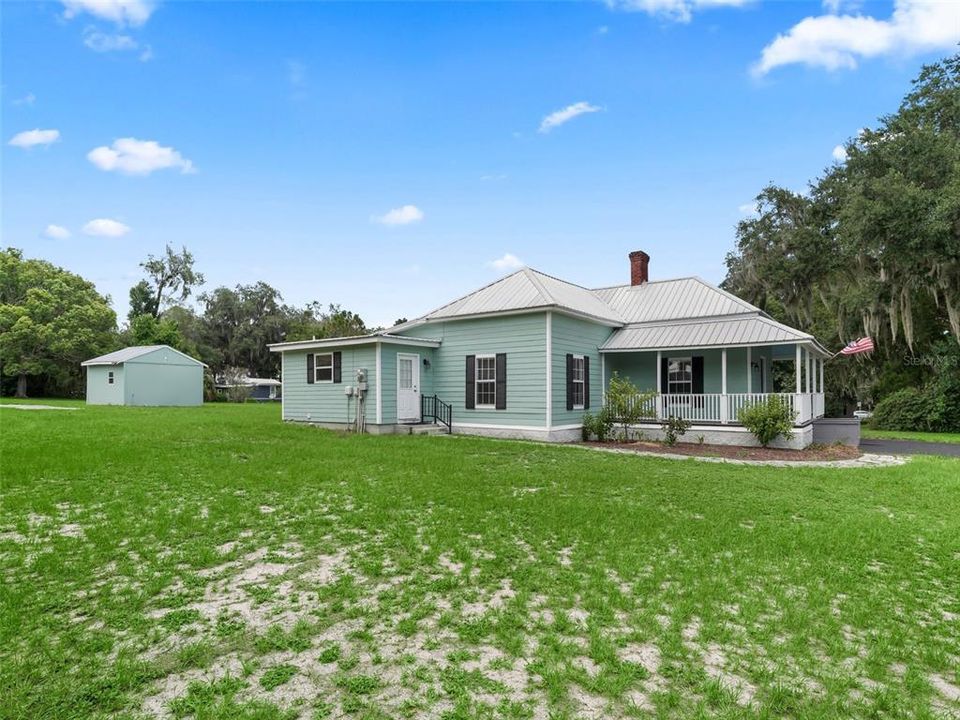 View of left side of home and back outbuilding