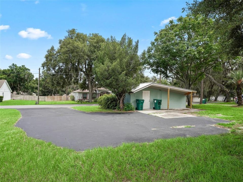 View of front electrified outbuilding looking toward the street. Note all the extra paved parking.  This building was once used as Lady Lake's food pantry.