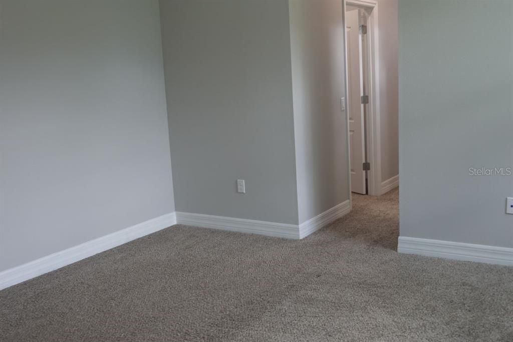 Primary Bedroom toward his/hers walk in closets and private bathroom.