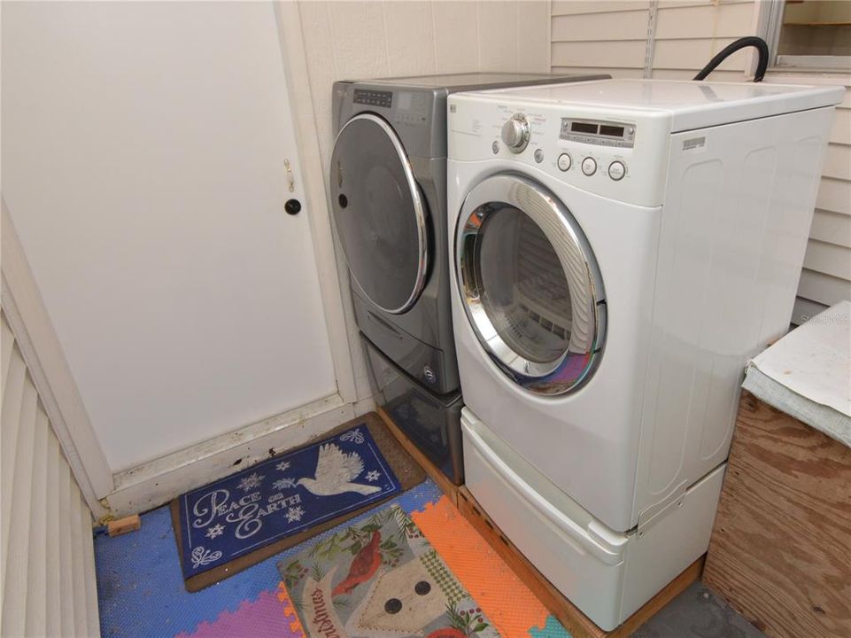 Utility area of carport with newer washer and dryer