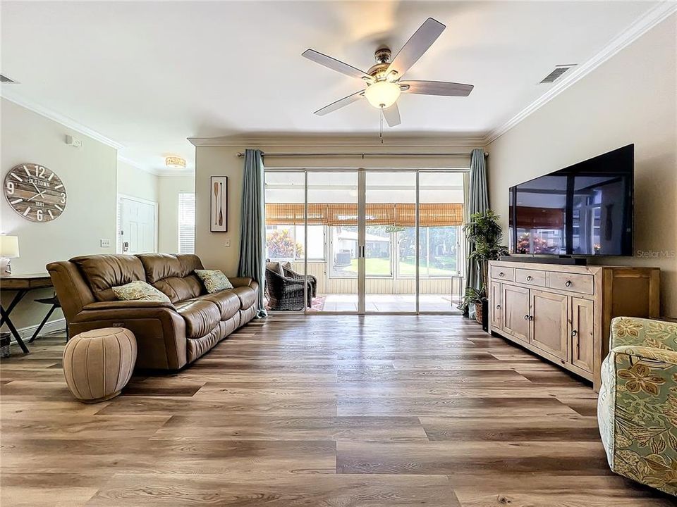 Full length view of the living room with the air conditioned Florida room beyond the sliding doors.