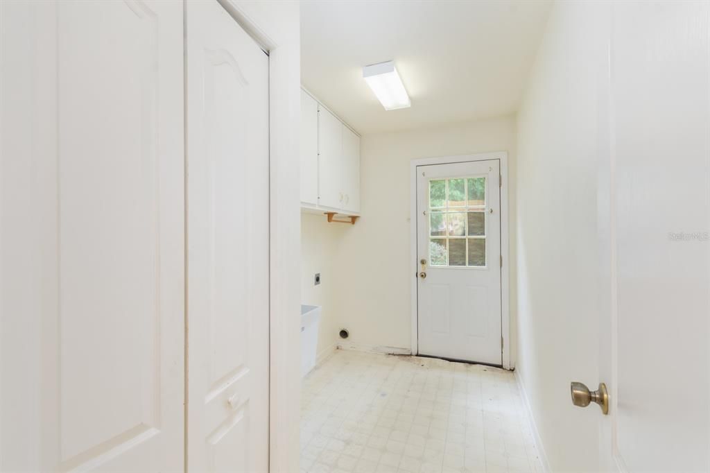 Downstairs Inside laundry room with door going out to side yard near garage