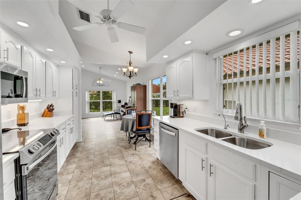 A view of the kitchen from the formal dining room; eat-in kitchen area and family room in the background