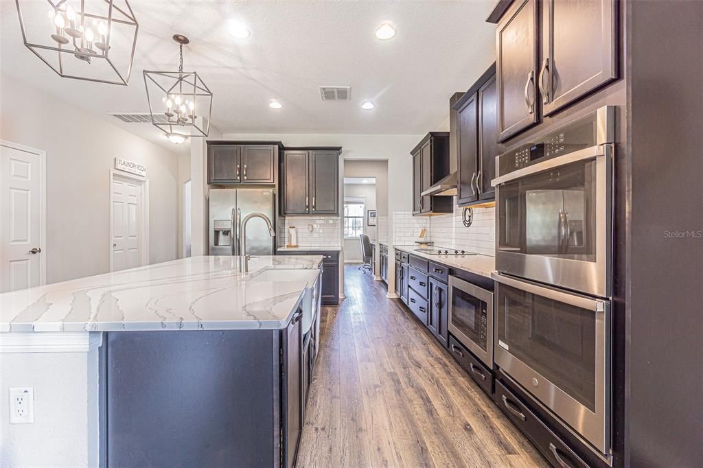 Gorgeous chef's kitchen with quartz countertops, accessible built-in microwave and double wall ovens