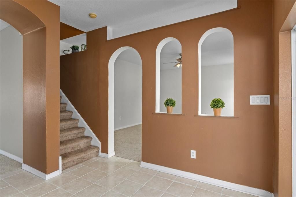 The family room is adjacent to the kitchen through the doorway and arches