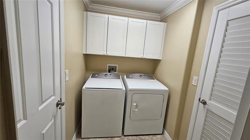 Inside Laundry room with cabinets