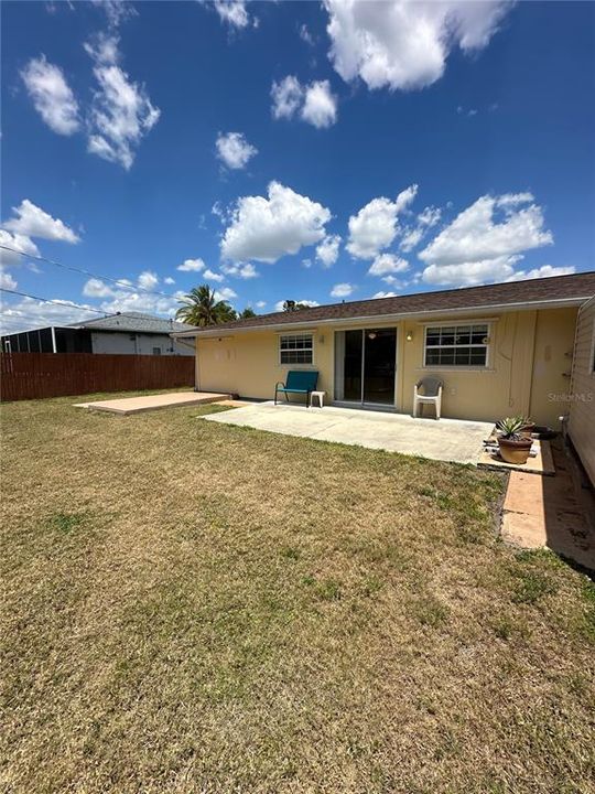 Large patio with a partially fenced in massive backyard